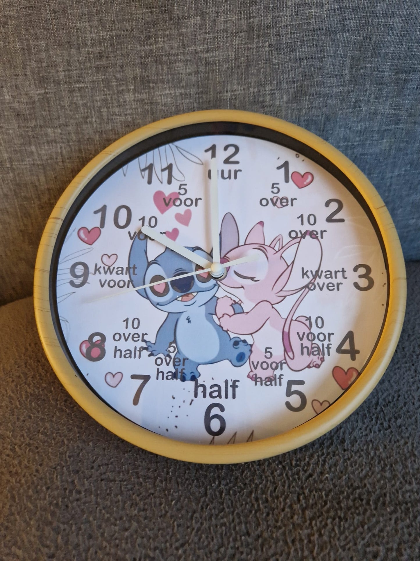 Kinderklok verkrijgbaar met een rand in wit, zandbeige, zwart of olijfgroen, met diverse themadesigns naar keuze. De klok heeft duidelijke cijfers en extra aanduidingen zoals "kwart voor" en "half" om kinderen te helpen bij het leren klokkijken. Een speelse en leerzame toevoeging aan elke kinderkamer!