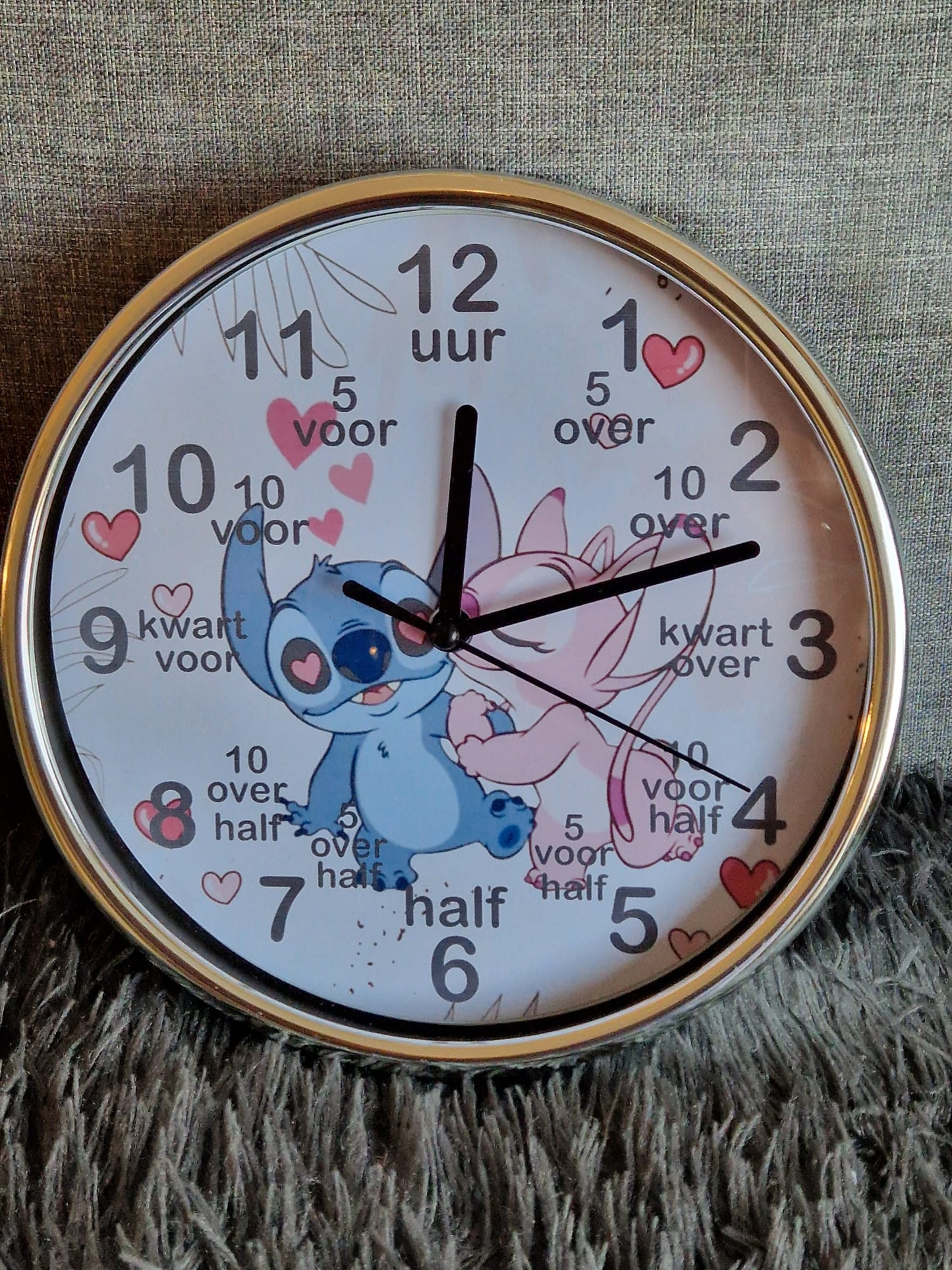 Kinderklok verkrijgbaar met een rand in wit, zandbeige, zwart of olijfgroen, met diverse themadesigns naar keuze. De klok heeft duidelijke cijfers en extra aanduidingen zoals "kwart voor" en "half" om kinderen te helpen bij het leren klokkijken. Een speelse en leerzame toevoeging aan elke kinderkamer!